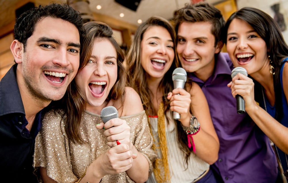 Group of friends karaoke singing at the bar